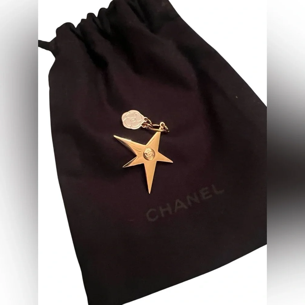 CHANEL Gold Star & small Camellia key Charm with black drawstring pouch.